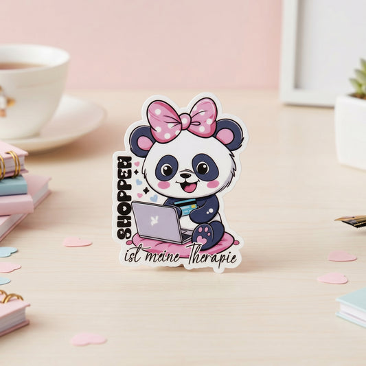 Kawaii Panda mit pinker Schleife, Laptop und Kreditkarte auf rosa Kissen, glänzend laminierter Die-Cut Vinyl Sticker mit Spruch Shoppen ist meine Therapie, weißer Rand, ca. 4,9×6,5 cm