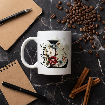 Personalisierte Keramiktasse mit floralem Anfangsbuchstaben L und Name Ludmila auf schwarzem Marmor mit Kaffeebohnen und Notizbuch, Sublimationsdruck 330ml