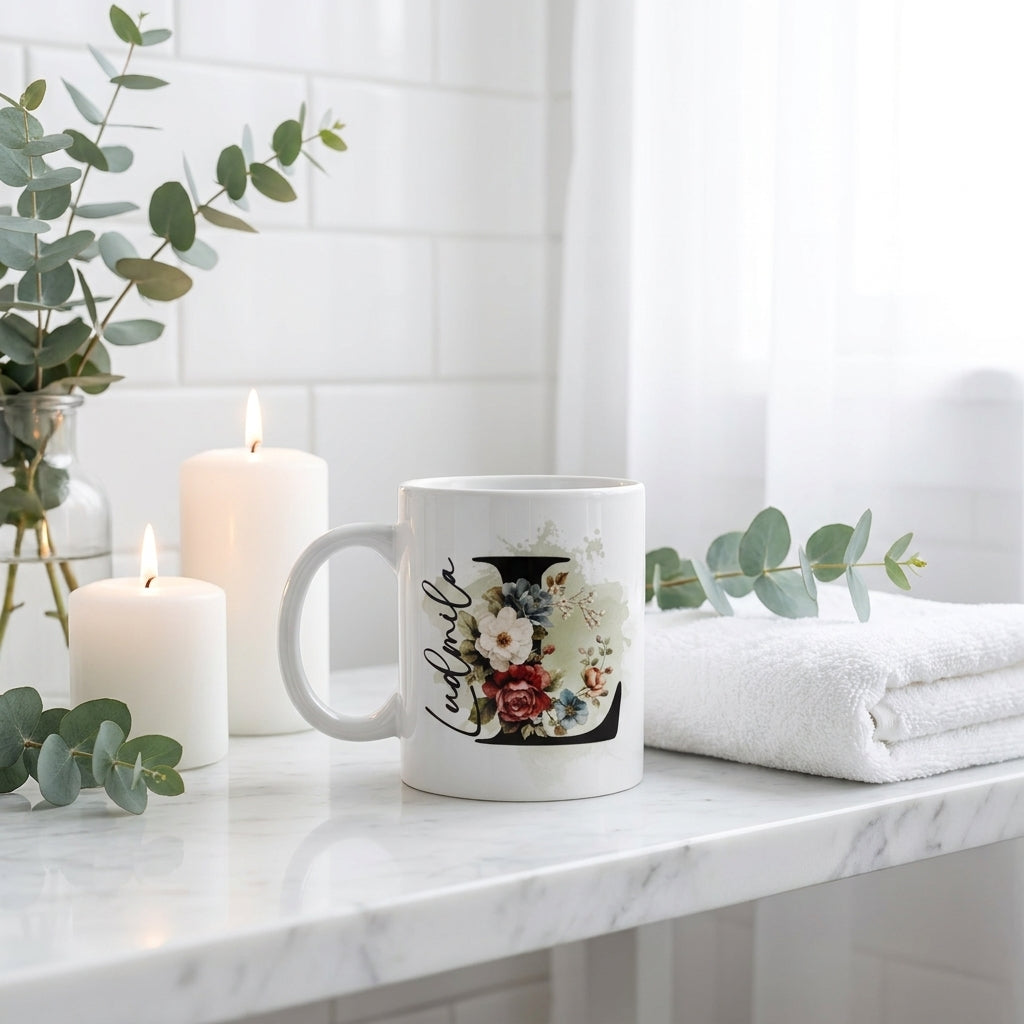Personalisierte Keramiktasse mit Blumen-Initiale L auf weißem Marmor neben brennenden Kerzen und Eukalyptuszweigen, cozy Wohndeko Geschenkidee